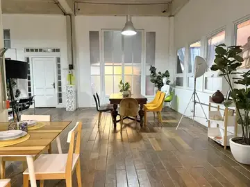 Comedor de Loft 3 junto a ventanales blancos, con piso de madera y sillas amarillas