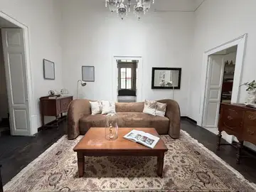 Sala de Casa Popotla con sofá café, piano y techos altos