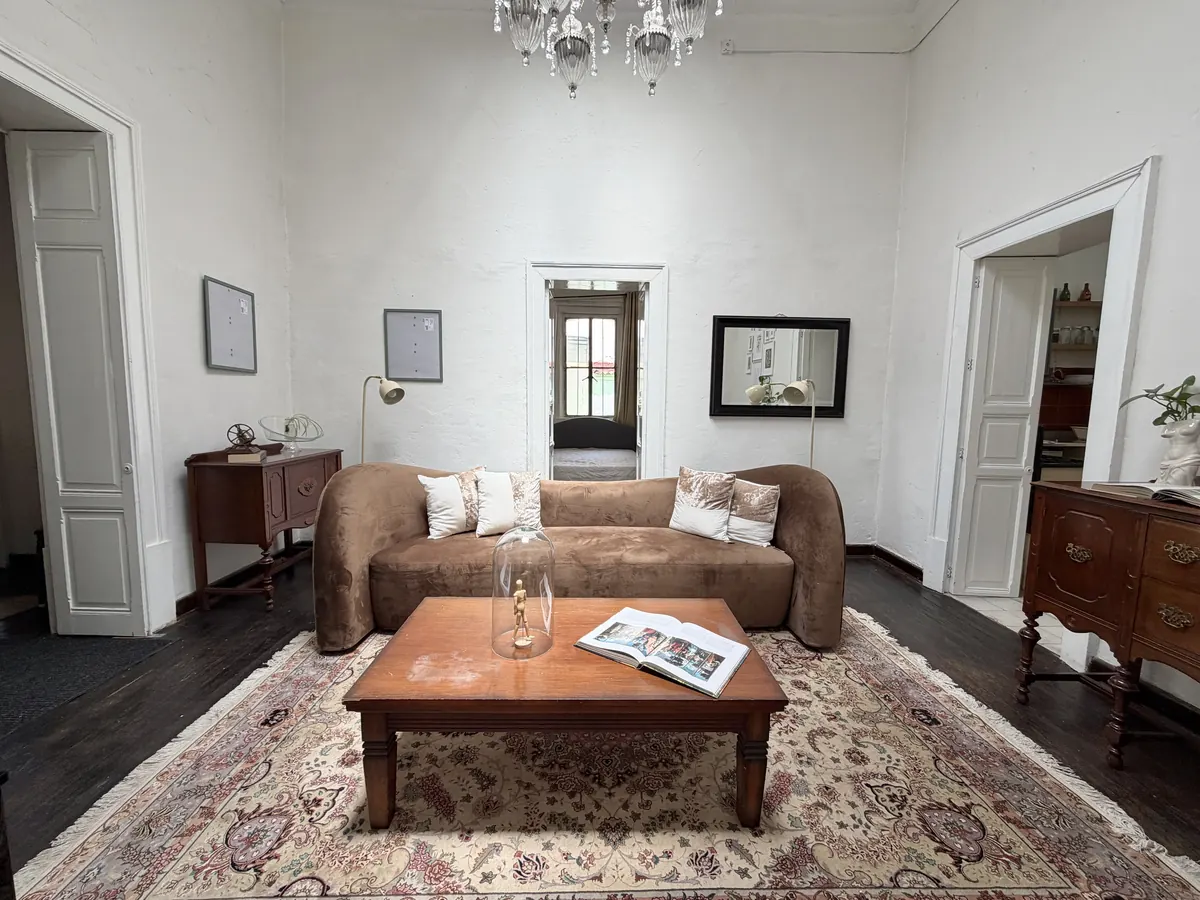 Sala de Casa Popotla con sofá café, piano y techos altos